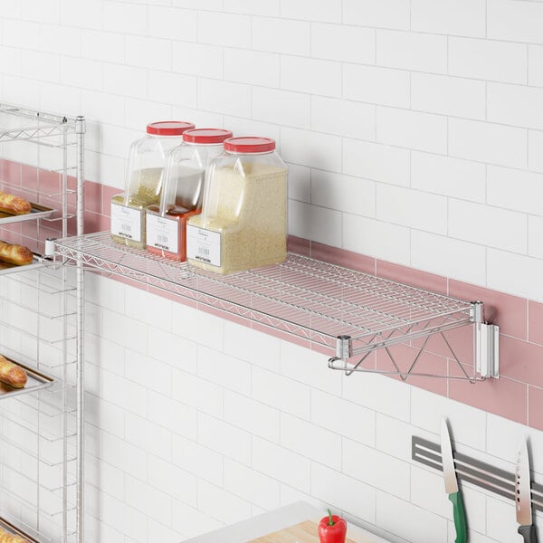 A Regency chrome wire wall mount shelf with containers of white food on it.