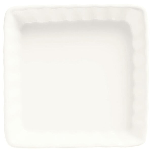 A white square Libbey Bedrock creme brulee dish with wavy edges.