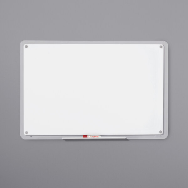 A white Quartet Total Erase whiteboard with a clear plastic frame and a red marker.