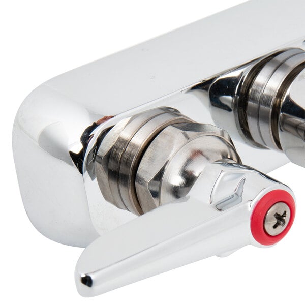 A T&S chrome wall mount faucet with two red lever handles.