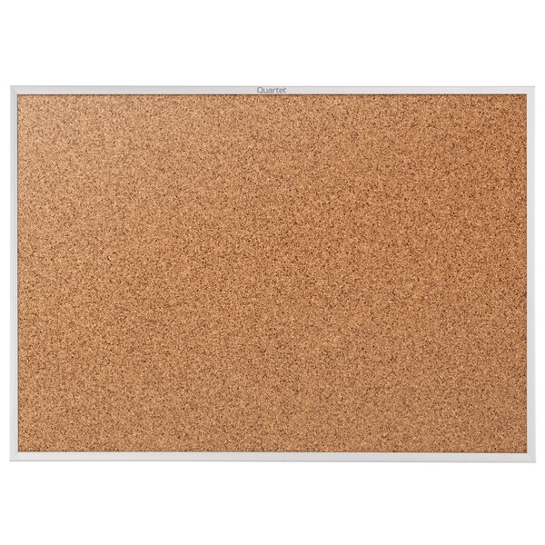 A Quartet cork board with a silver aluminum frame.