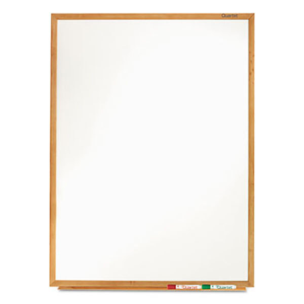 A Quartet melamine whiteboard with an oak finish frame.