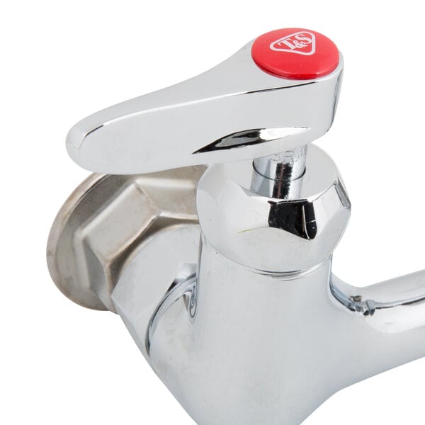 A T&S chrome wall mount faucet with lever handles and a red button.