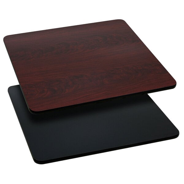 A black and mahogany reversible laminated square table top on a table.