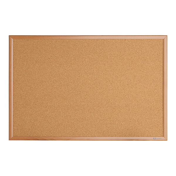 A close-up of a Quartet cork board with an oak finish wooden frame.