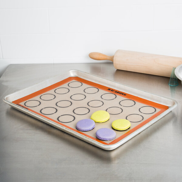 A baking sheet with macarons on a Sasa Demarle SILPAT baking mat.