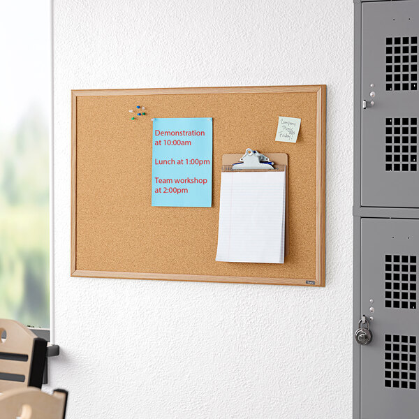 A Quartet cork board with an oak finish frame.