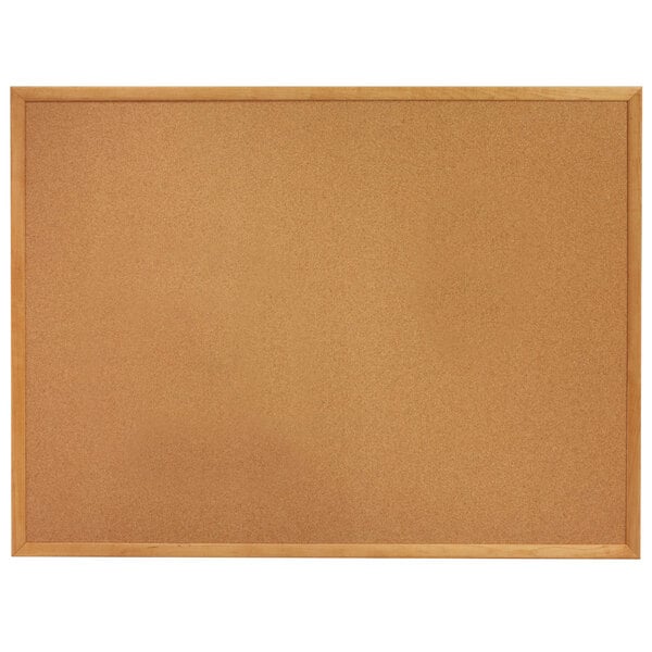 A Quartet cork board with an oak wood frame.