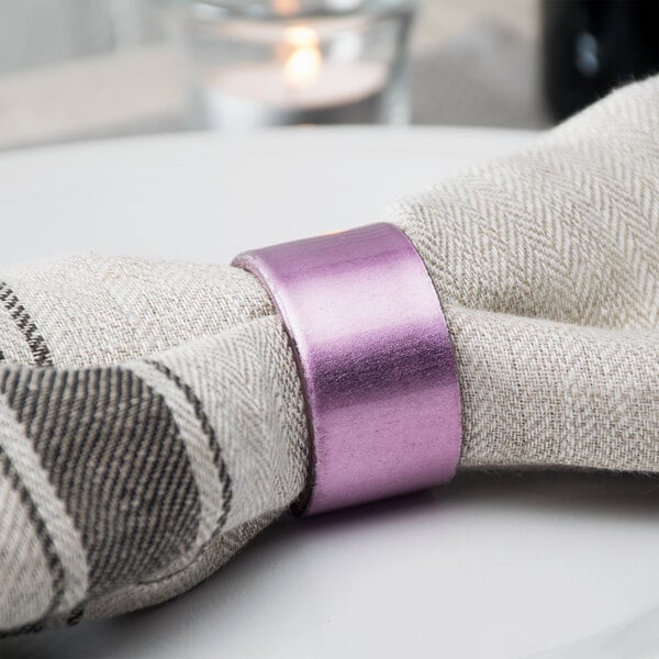 A purple napkin with a Tabletop Classics by Walco purple polypropylene napkin ring on it.