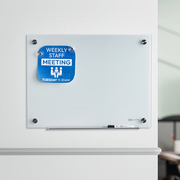 A Quartet white glass markerboard with a blue sign and marker.