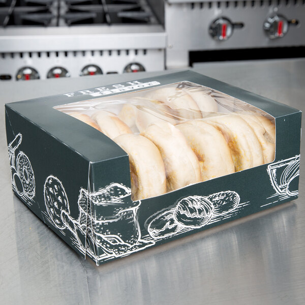 A box of donuts on a counter with a Fresh print design on the box.
