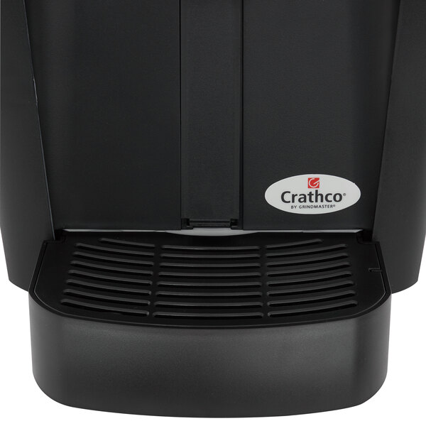 A black Crathco beverage dispenser with a white fruit decal.