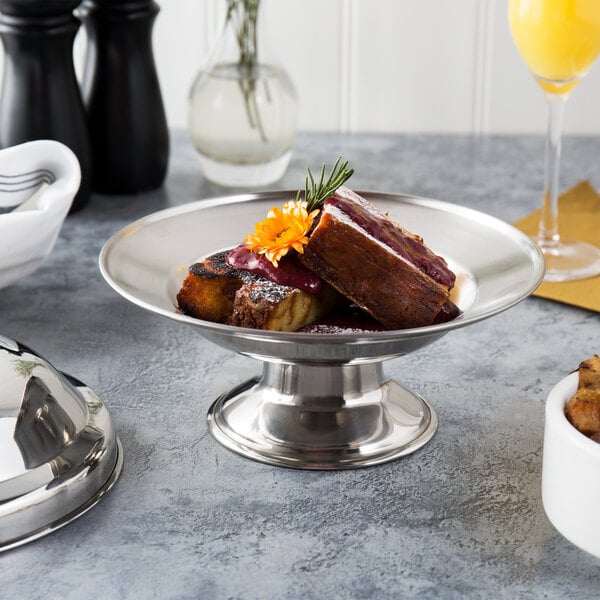 A Town stainless steel serving dish with food on a table.