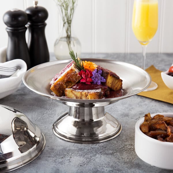 A Town stainless steel serving bowl with food on a table.