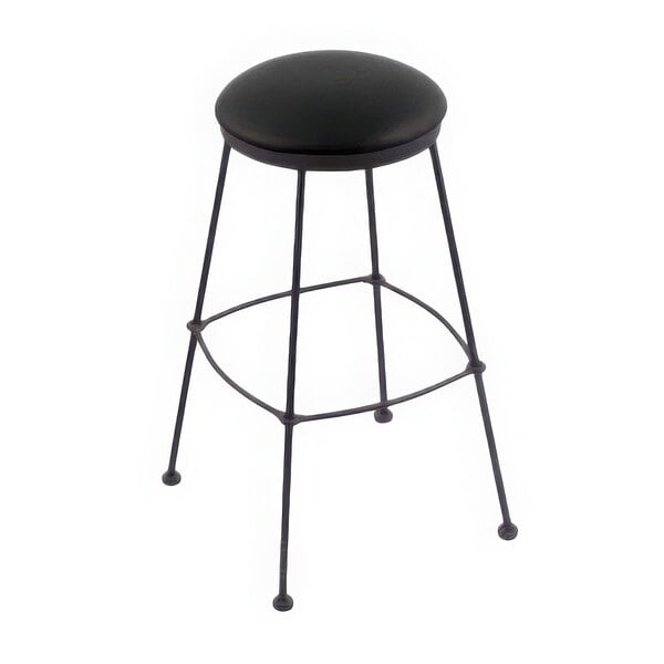 A Holland Bar Stool black steel counter height stool with a black vinyl seat.