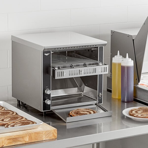 A Vollrath conveyor toaster with food on it.