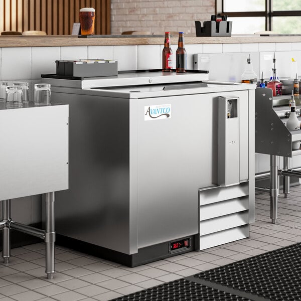 An Avantco stainless steel horizontal bottle cooler on a counter in a restaurant.