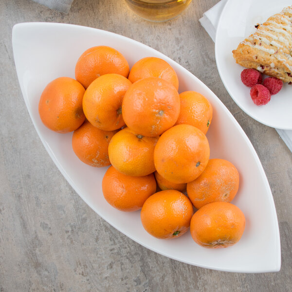 A bowl of oranges on a counter.