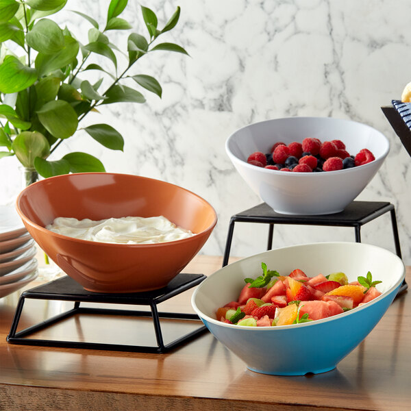 A variety of GET Diamond Harvest melamine bowls filled with fruit and whipped cream.
