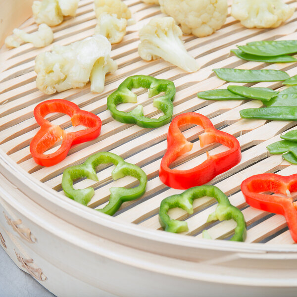 A Town bamboo steamer tray with vegetables on it.