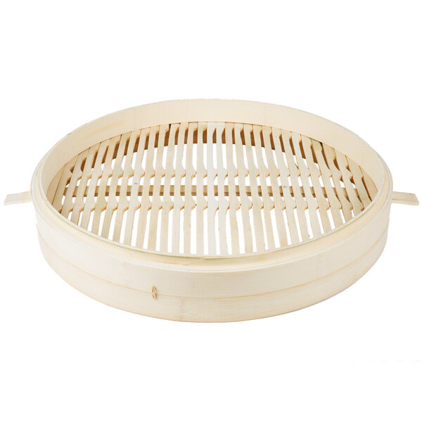 A round bamboo steamer with wooden handles.