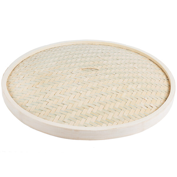 A round bamboo steamer cover with a woven pattern.