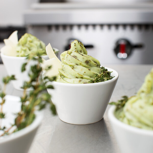 Green food piped with an Ateco Canvas Pastry Bag into white cups.