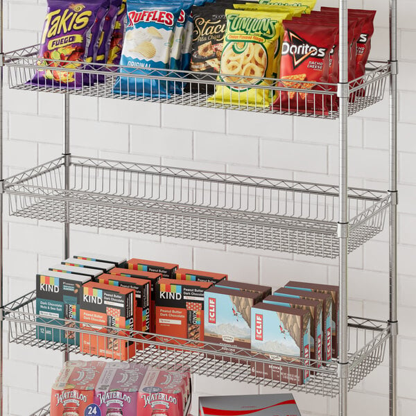 A Regency metal shelf basket with snacks on it.