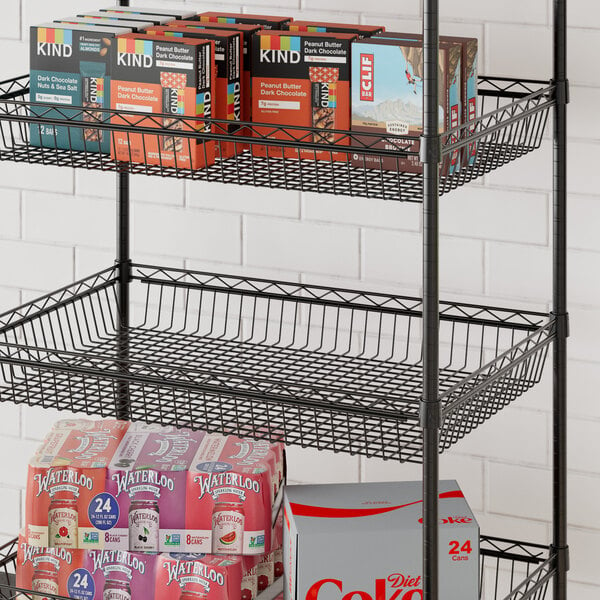 A Regency black metal shelf basket on a shelf with various products.