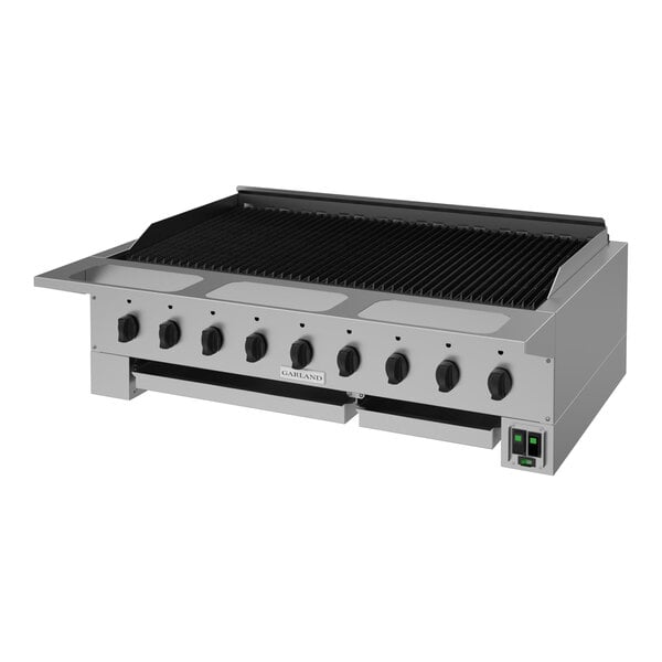 A large stainless steel commercial charbroiler with multiple control knobs and a grated cooking surface.