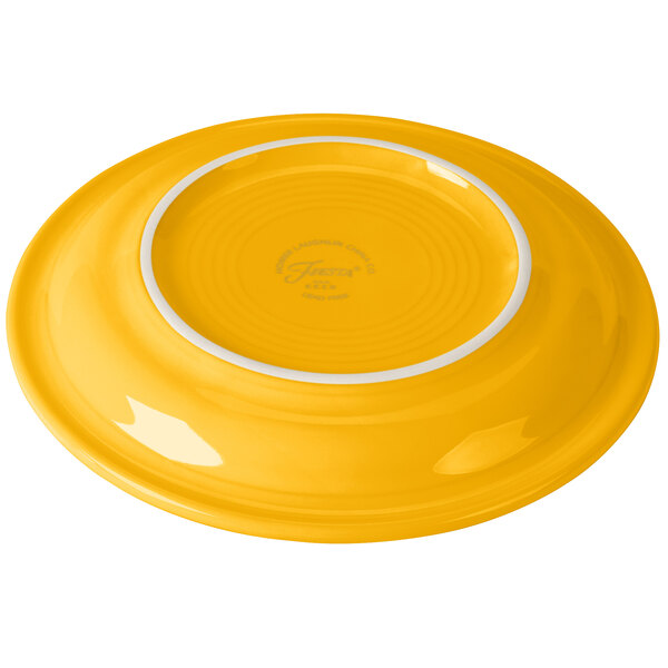 A Fiesta Daffodil china appetizer plate with a yellow center and white rim.