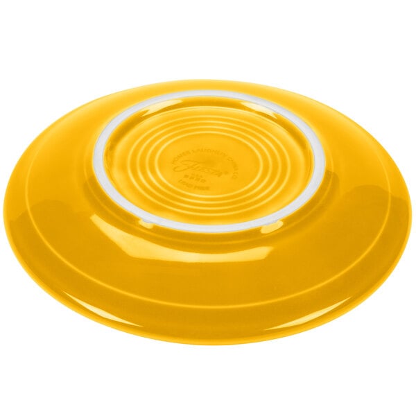 A yellow Fiesta saucer with a white rim.