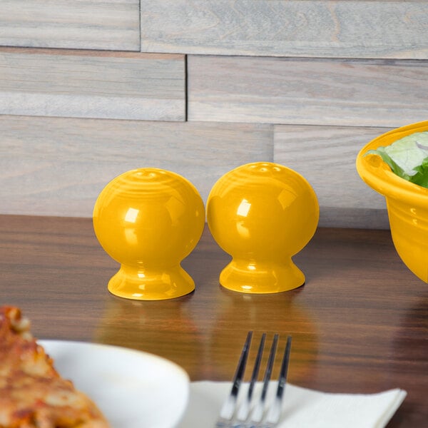 A yellow Fiesta salt and pepper shaker on a table.