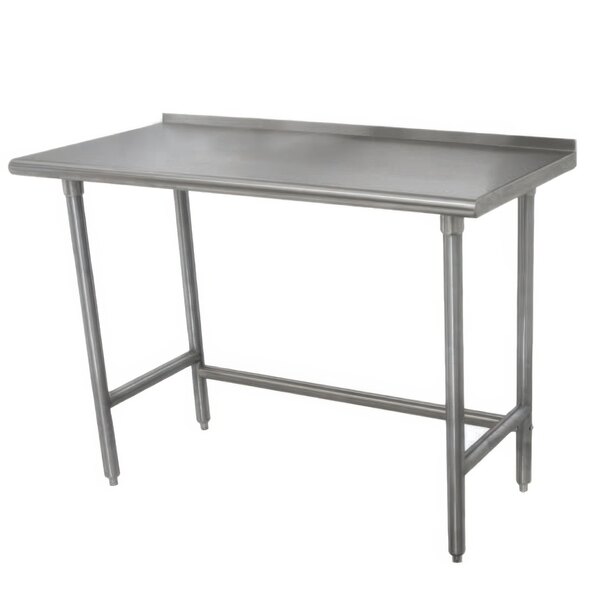 A stainless steel Advance Tabco work table with metal legs and a backsplash.