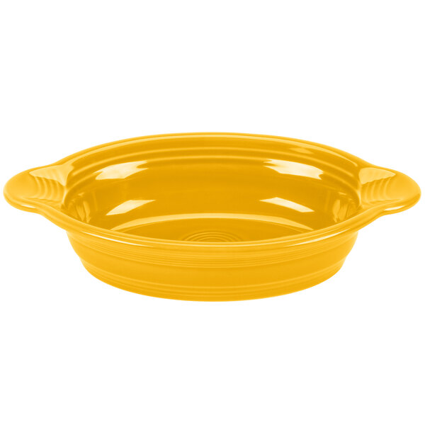 A yellow oval casserole dish with handles on a white background.