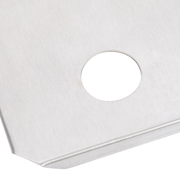 A stainless steel metal plate with a hole in the middle.