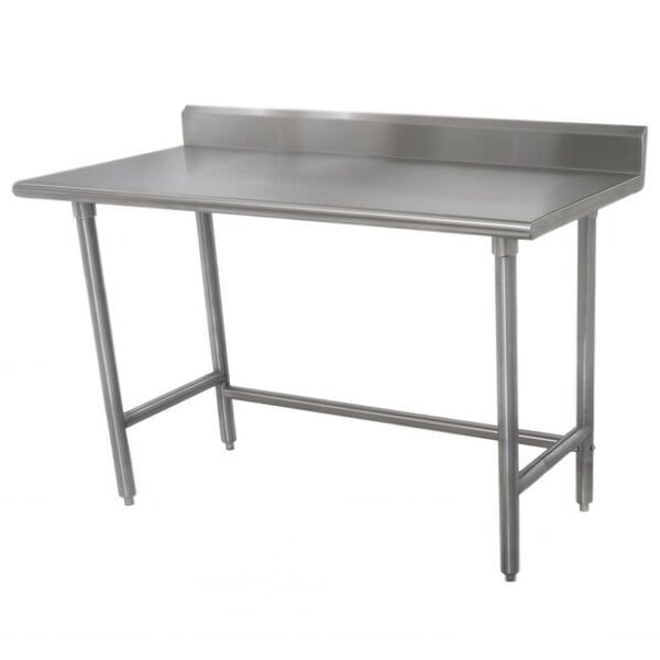 An Advance Tabco stainless steel work table with a backsplash and galvanized legs.