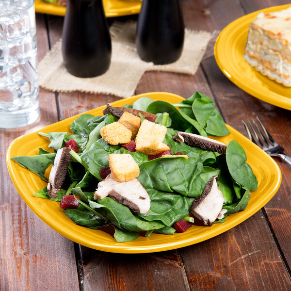 A Fiesta square salad plate with salad, chicken, and croutons on it.
