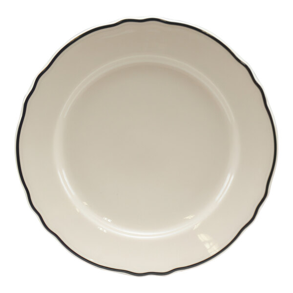 A white circular china bread and butter plate with black scalloped trim.