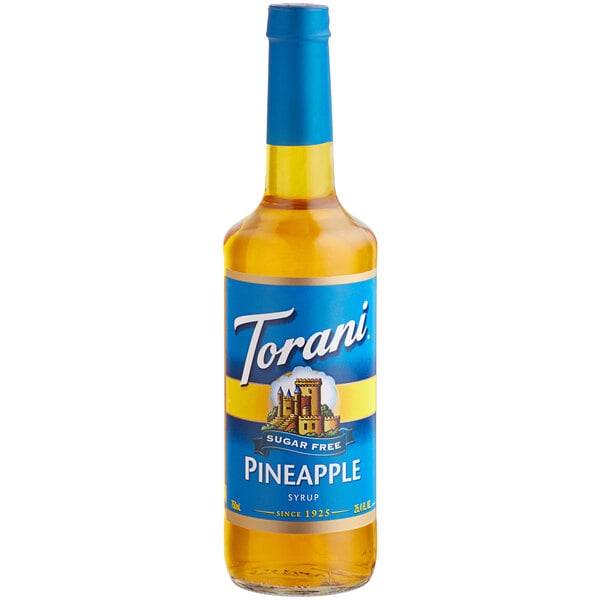 A close-up of a Torani Sugar-Free Pineapple Flavoring Syrup 750 mL glass bottle with a blue label.