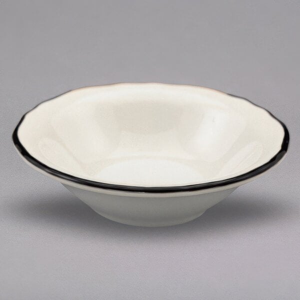 A white Homer Laughlin china bowl with a black scalloped rim.