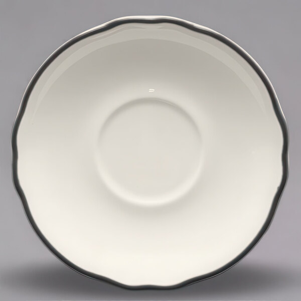 A white saucer with a black scalloped rim.