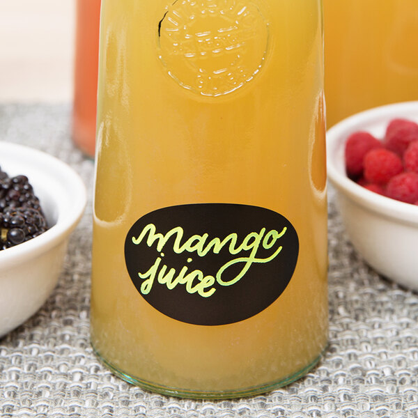 A bowl of blackberries and raspberries with a Franmara neon yellow glass marker on a table in a juice bar.
