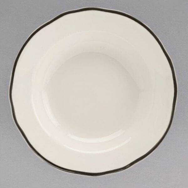 A white china bowl with a black scalloped rim.