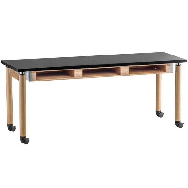 A black table with wooden legs and wheels.