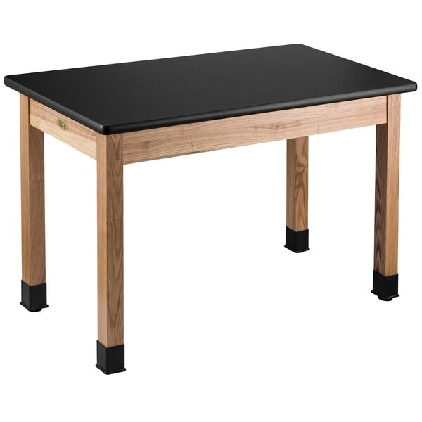 A black National Public Seating science lab table with wooden legs.