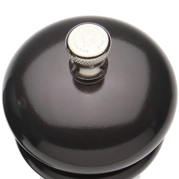 A black pepper mill with a silver knob.