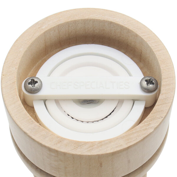 A wooden pepper mill and salt mill with white circular caps.