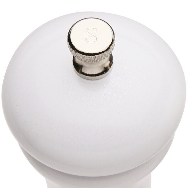 A white pepper mill with a silver knob.