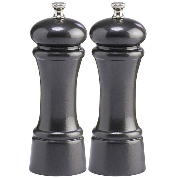 Two black pepper mills with silver caps.